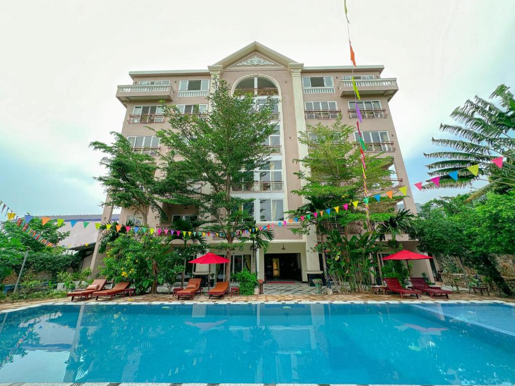 a hotel with a swimming pool in front of a building at Summer Resort in Kep
