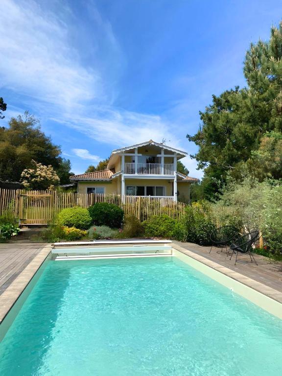 a house with a swimming pool in front of a house at Villa des Sables in Lège-Cap-Ferret