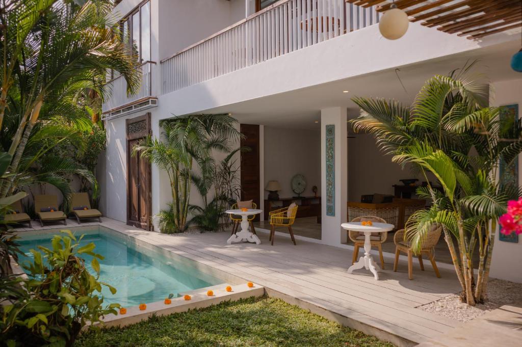 a house with a swimming pool and a patio at The Bed by The Sea in Canggu