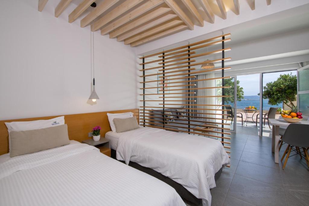 two beds in a room with a view of the ocean at Balos Beach in Kissamos