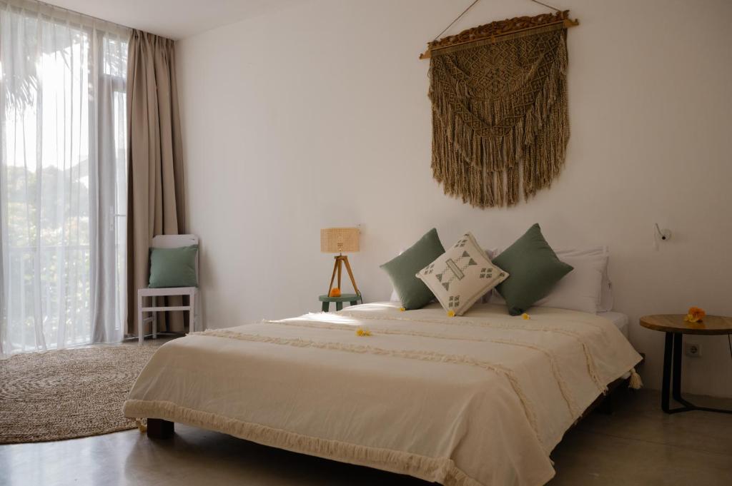 a bedroom with a large bed and a window at The Bed by The Sea in Canggu