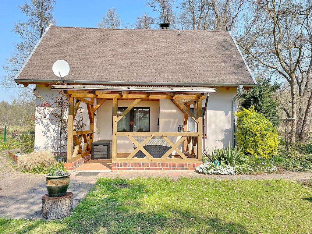 ein kleines Haus mit einer Veranda und einer Holztür in der Unterkunft Ferienhaus Eisvogel in Lübbenau