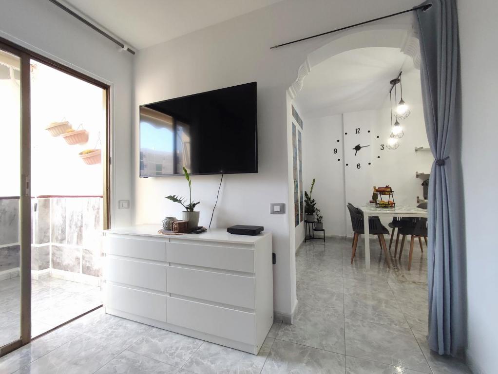 een woonkamer met een dressoir met een tv aan de muur bij Vivienda Agaete Parque in Playa del Inglés
