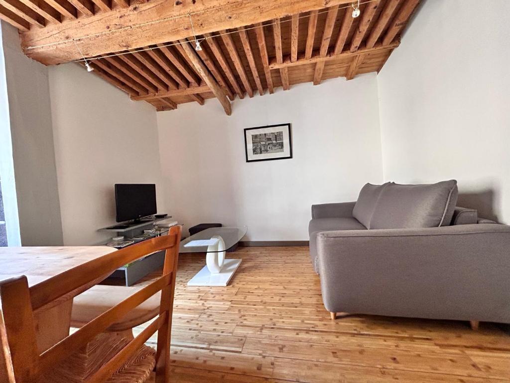 ein Wohnzimmer mit einem Sofa und einem Tisch in der Unterkunft Le Pradet - Maison de ville rue piétonne animée in Clermont-Ferrand