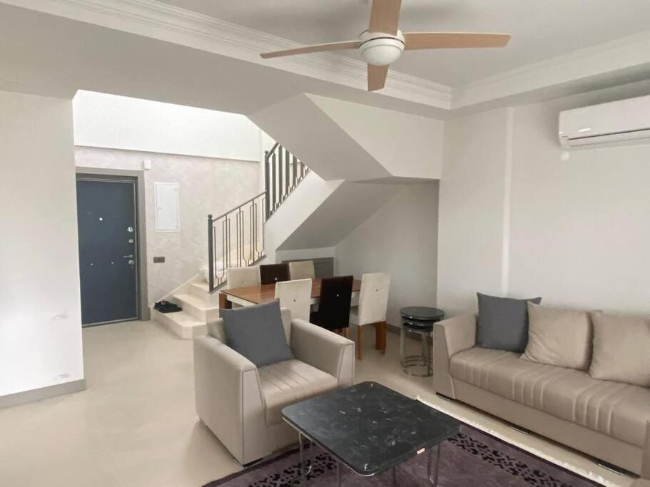 uma sala de estar com um sofá e uma ventoinha de tecto em Moderne Villa in Kuşadası em Kusadasi