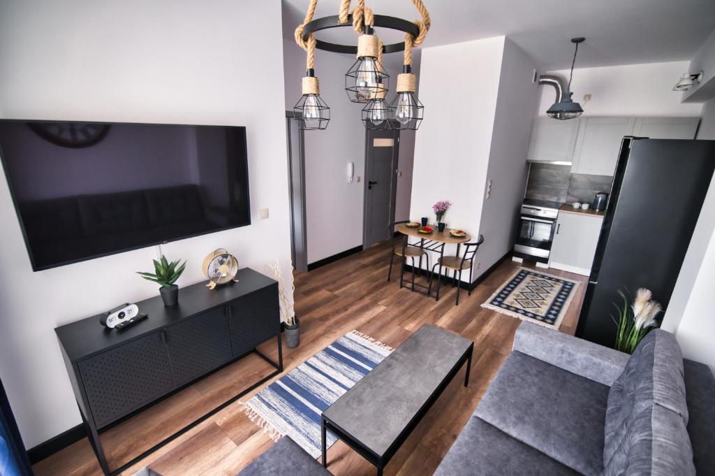 een woonkamer met een grote flatscreen-tv bij LOFT 24 by Housine in Zator