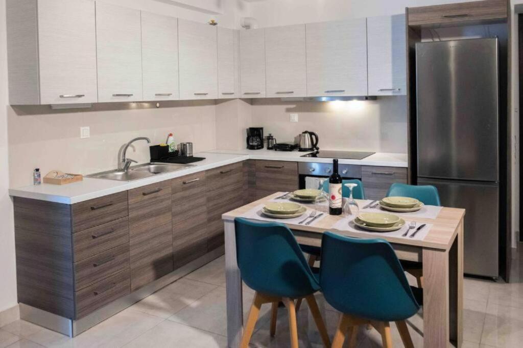 een keuken met een tafel met stoelen en een koelkast bij Modern spacious apartment located in Piraeus (B8) in Piraeus