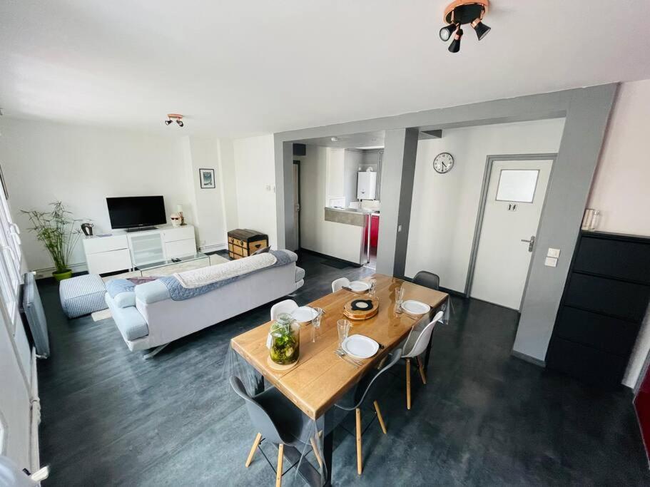 sala de estar con mesa y sofá en L'appartement Lafayette rive gauche en Rouen