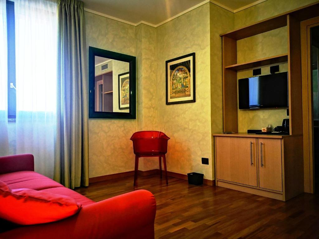a living room with a red couch and a television at ALBERGO BALDAZZI 1916 in Zavattarello