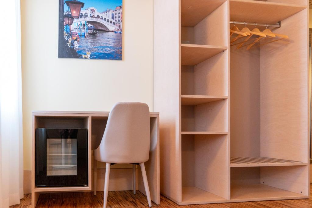 a room with a chair and a desk and a fireplace at Hotel Autoespresso Venice - Atika & Atif in Marghera
