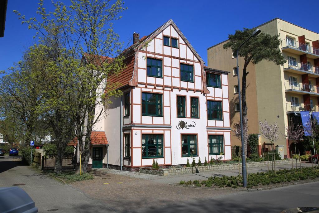 a white building with black windows on a street at Villa Alexandra in Świnoujście