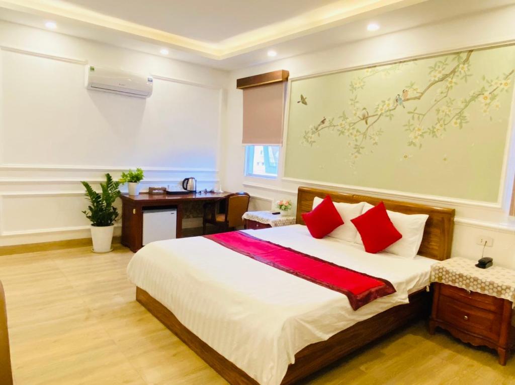 ein Schlafzimmer mit einem großen Bett mit roten Kissen in der Unterkunft Nhu Y Hotel in Ho-Chi-Minh-Stadt