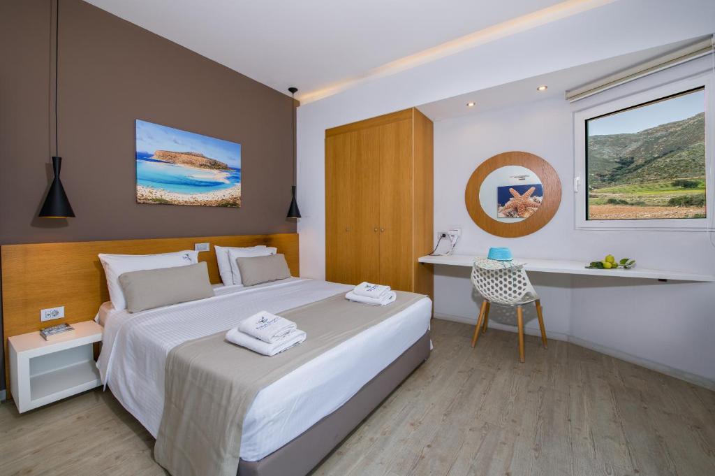 a bedroom with a large bed and a desk at Balos Beach in Kissamos