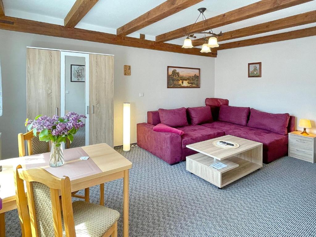 un soggiorno con divano viola e tavolo di Ferienwohnung Hibiskus a Lübbenau