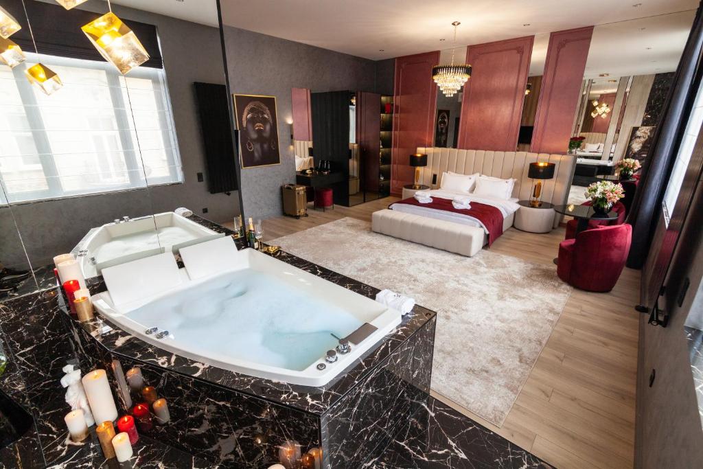 a bathroom with a tub and a bed in a room at ARISTO Jacuzzi Hotel in Lviv