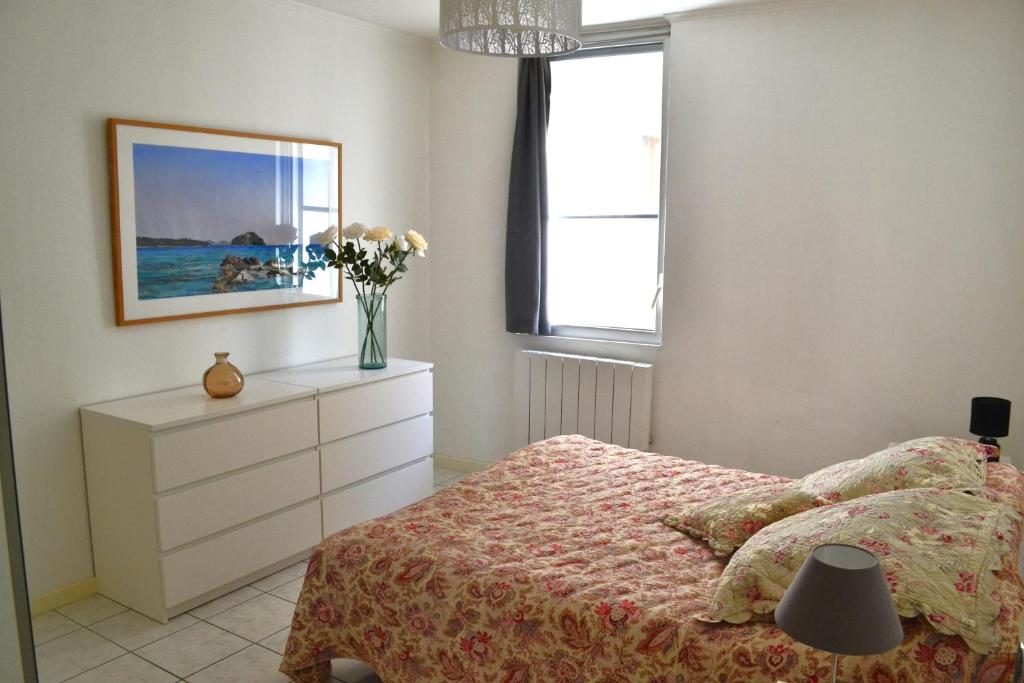 ein Schlafzimmer mit einem Bett und einer Blumenvase in der Unterkunft Charmante maison centre historique d'Arles in Arles