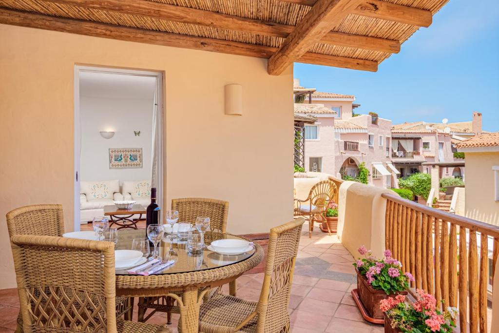 a patio with a table and chairs on a balcony at Casa Olivastra in Porto Cervo