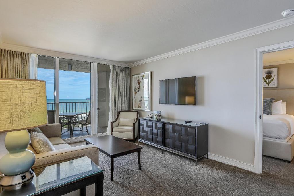 a hotel room with a bed and a living room at Seashells and Sunshine Marco Beach Ocean Resort 1105 in Marco Island