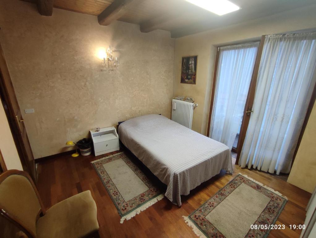 Habitación pequeña con cama y ventana en Zugliano udine, en Zagliano