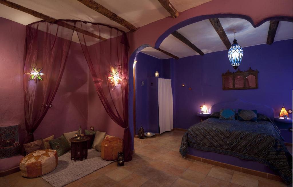 a bedroom with a bed in a purple room at El Planeta Escondido in Losana de Pirón