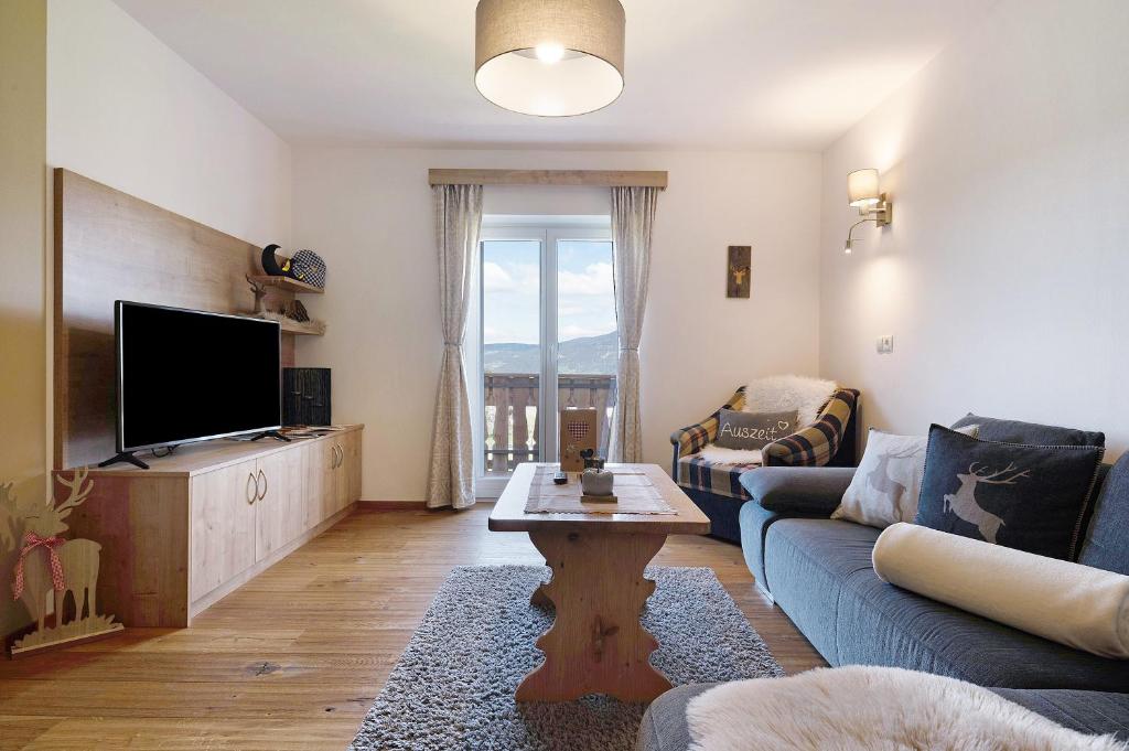 a living room with a couch and a tv at Schererhof Dolomitenblick in Castelrotto