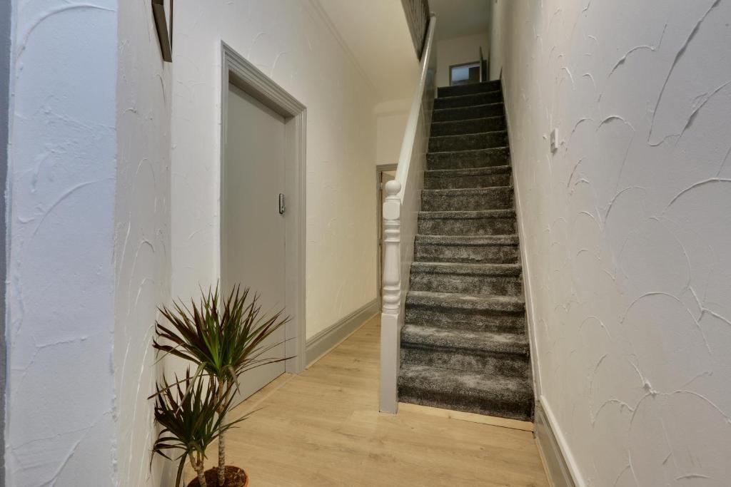 un escalier dans une maison avec un mur blanc dans l'établissement Home from Home 4-Bed Townhouse - Ideal for Families, Groups & Contractors, Free Parking, Pet Friendly, Netflix, à Walkley