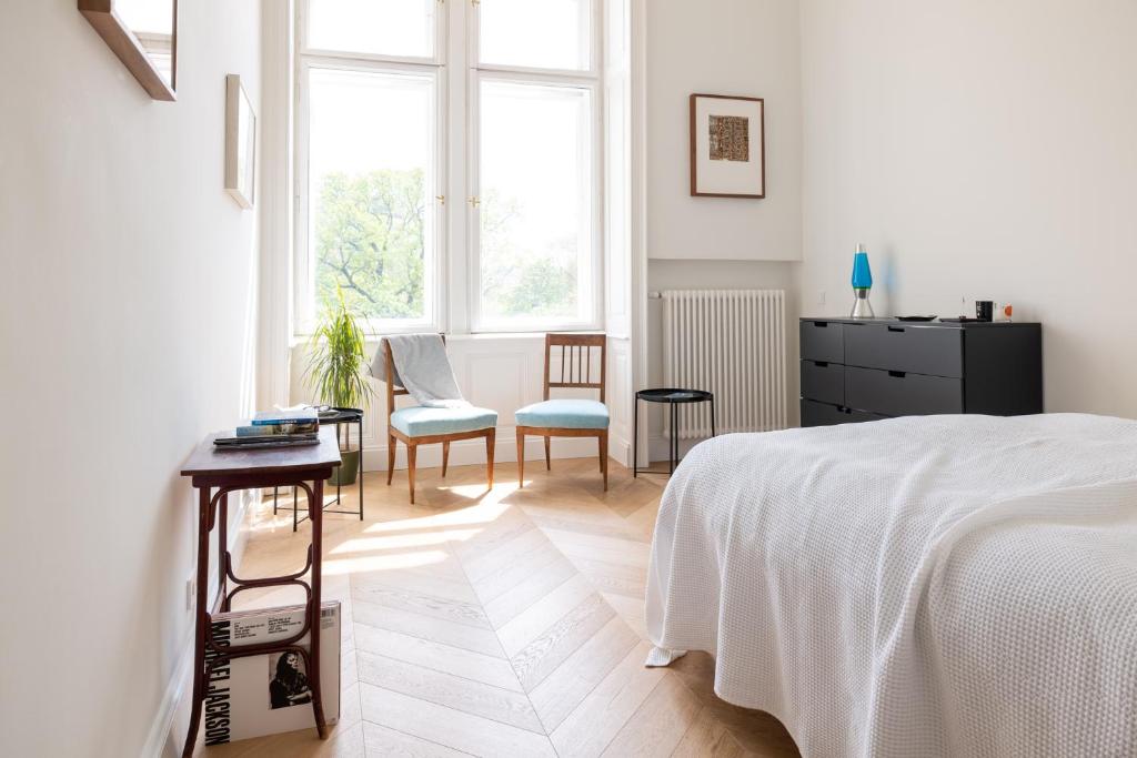 - une chambre blanche avec un lit, une table et des chaises dans l'établissement Stunning Apartment in City Center, à Vienne