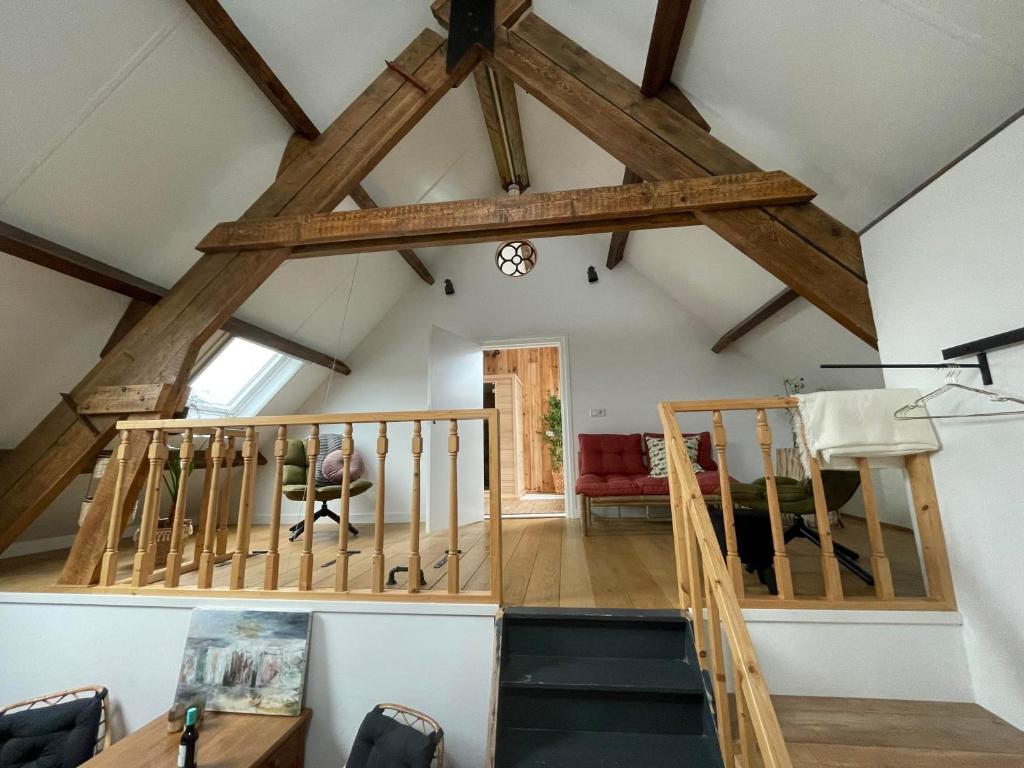 a living room with a vaulted ceiling with wooden beams at B & B 'Droom in de polder de Suite met prive sauna in Arnemuiden