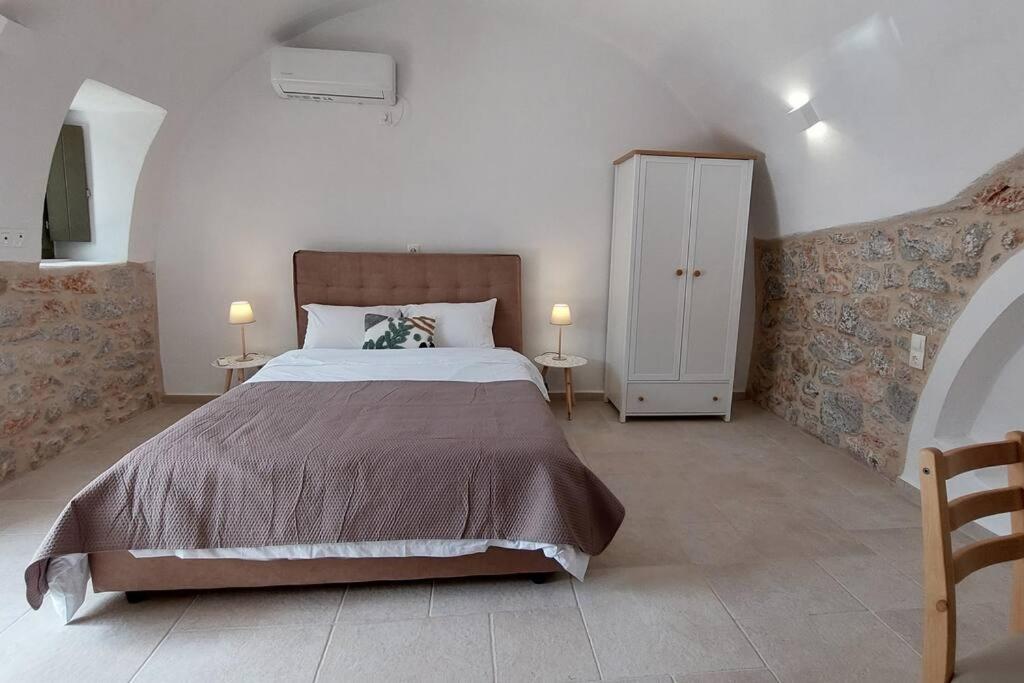 1 dormitorio con 1 cama, 2 mesas y armario en 200 year old 'Kamara Suite' with private garden, en Pyrgos Dirou