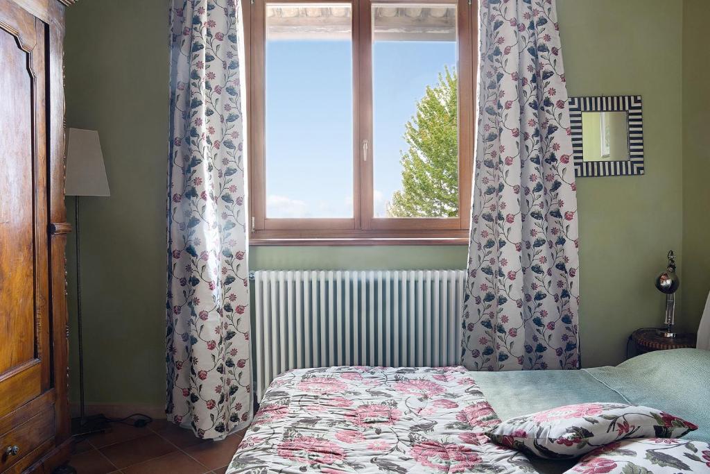 sypialnia z łóżkiem i oknem w obiekcie La Corte di Langa alloggio Agata w mieście Albaretto Della Torre 