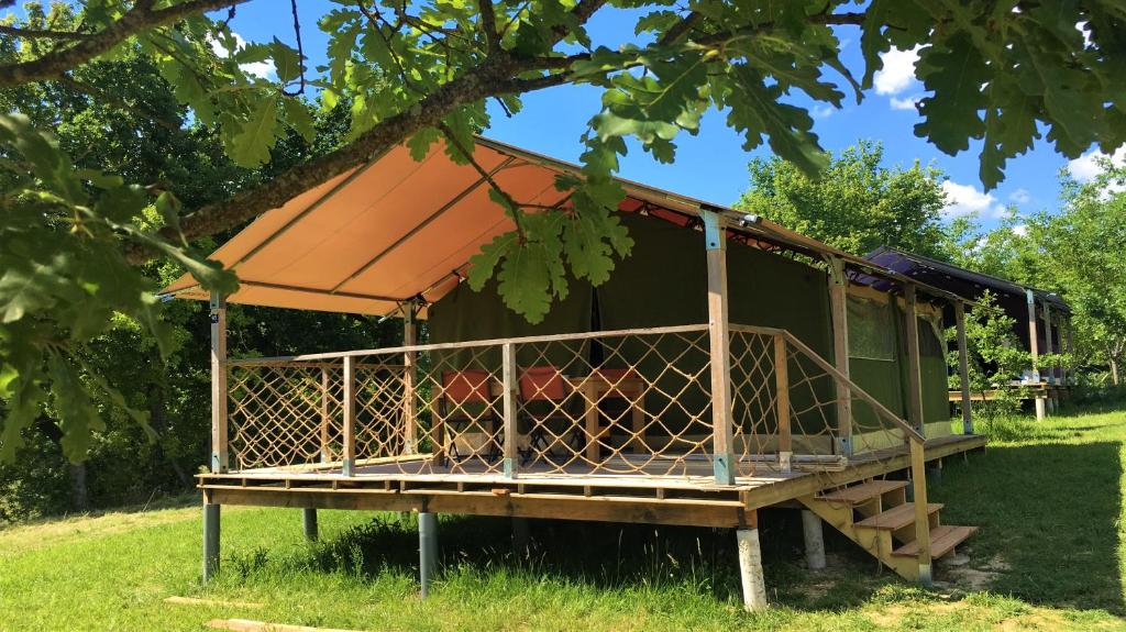 a tree house with an orange roof in the grass at Maison d hôtes Casa Sana in Pillac