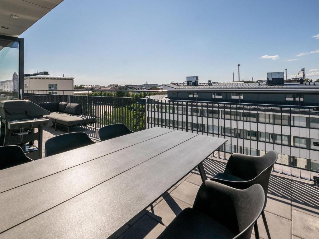 uma cafetaria com mesas e cadeiras de madeira num telhado em Holiday Home Helsinki rooftop by Interhome em Helsinque