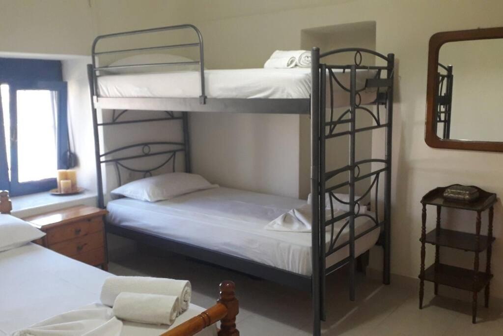 a bedroom with two bunk beds and a mirror at Lovely Vacation Home in Poros