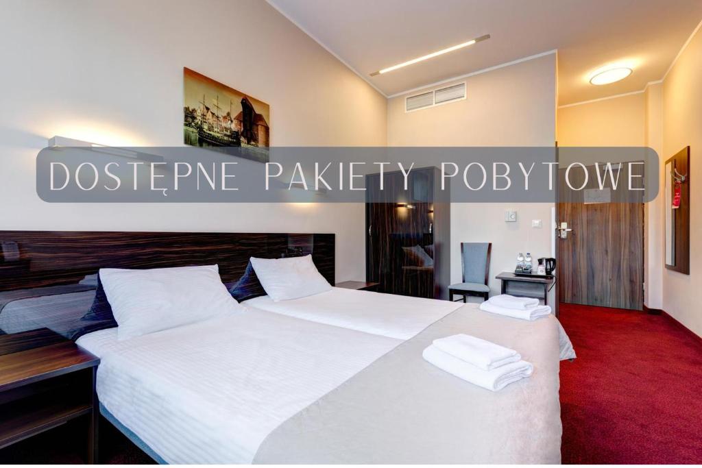 a bedroom with a large bed with white sheets at Focus Hotel Gdańsk in Gdańsk