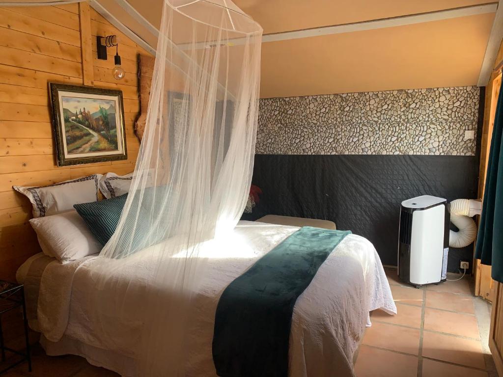 a bedroom with a bed with a mosquito net at Casa kintsugi in Masquefa