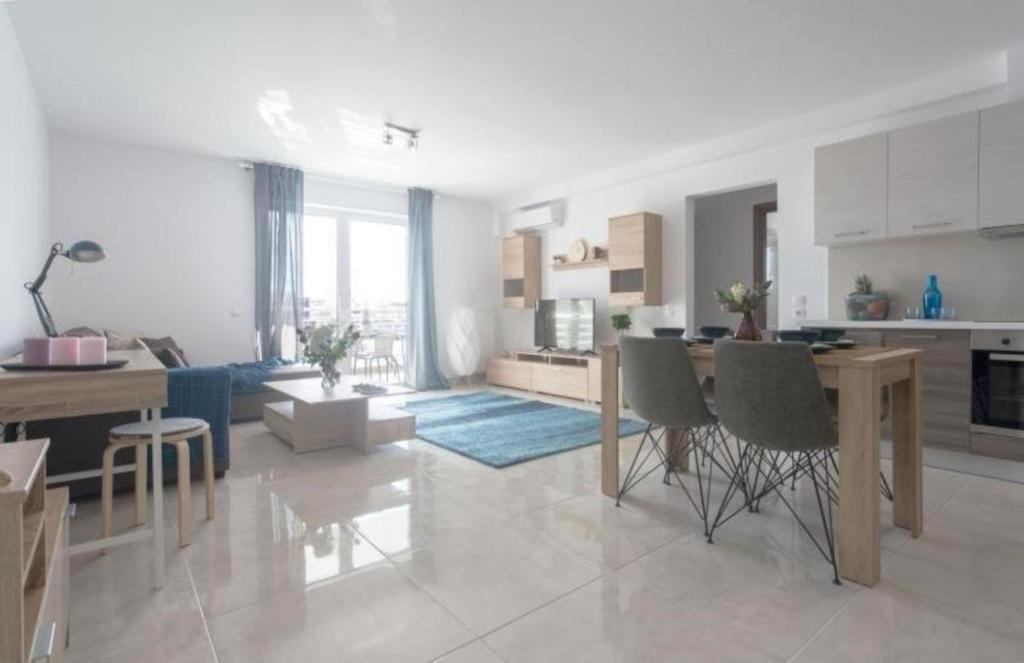 a kitchen and living room with a table and chairs at New spacious apartment located in Piraeus in Piraeus