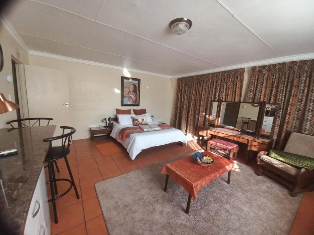 une chambre d'hôtel avec un lit et un salon dans l'établissement Beit-El BnB, à Polokwane