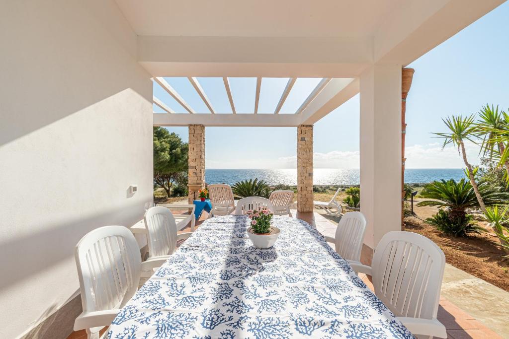 a dining room with a table and chairs and the ocean at Casa Lia e Nino a San Vito Lo Capo in San Vito lo Capo
