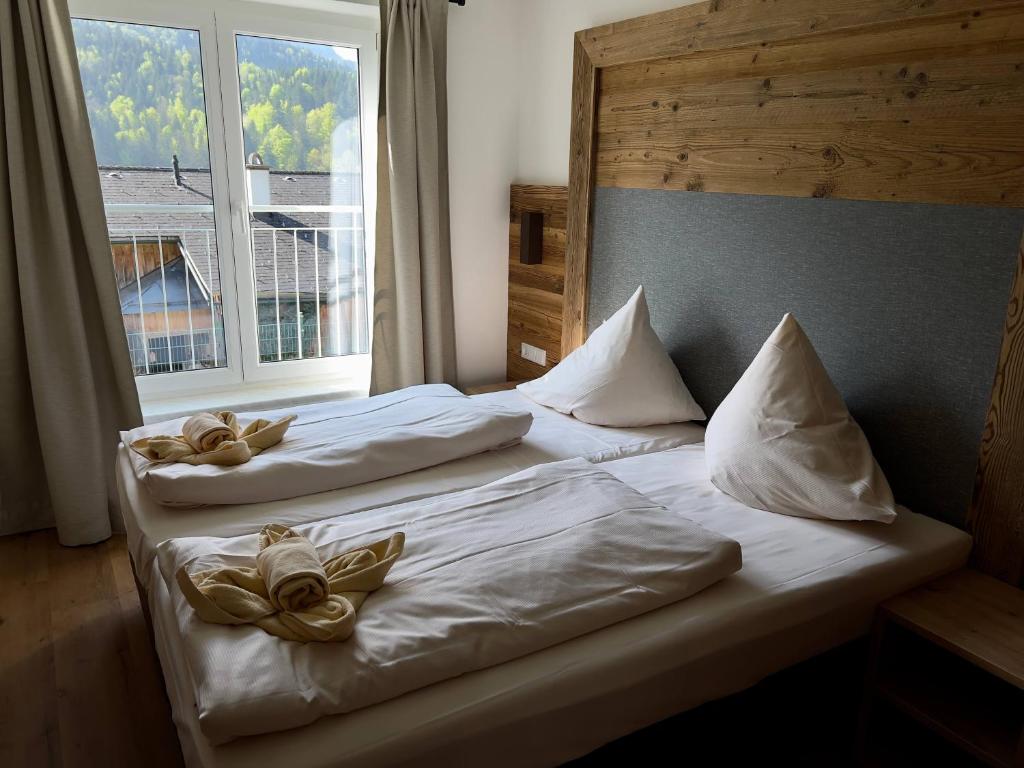 two beds in a hotel room with a window at Ferienwohnung Grundlsee in Grundlsee