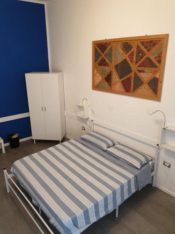 Un dormitorio con una cama y un cuadro en la pared. en Da Laura, en Cagliari