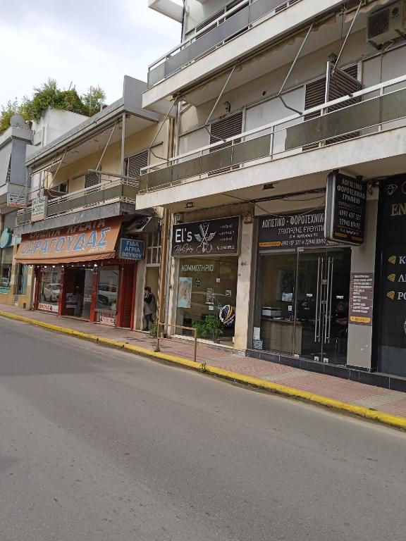 uma fila de lojas ao lado de uma rua em DIAS APPARTMENT em Artemida