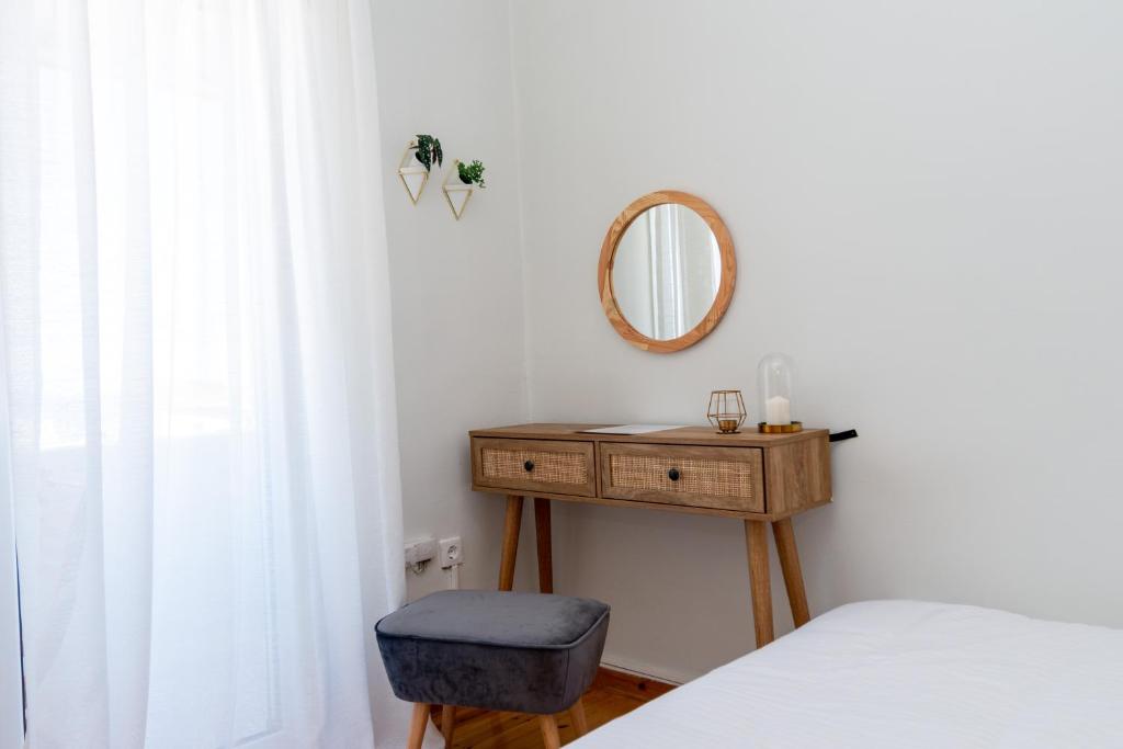 um quarto com uma cama e uma mesa com um espelho em Zoe's apartment em Zakynthos