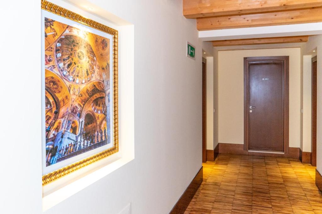a hallway with a painting on the wall and a door at Hotel Autoespresso Venice - Atika & Atif in Marghera