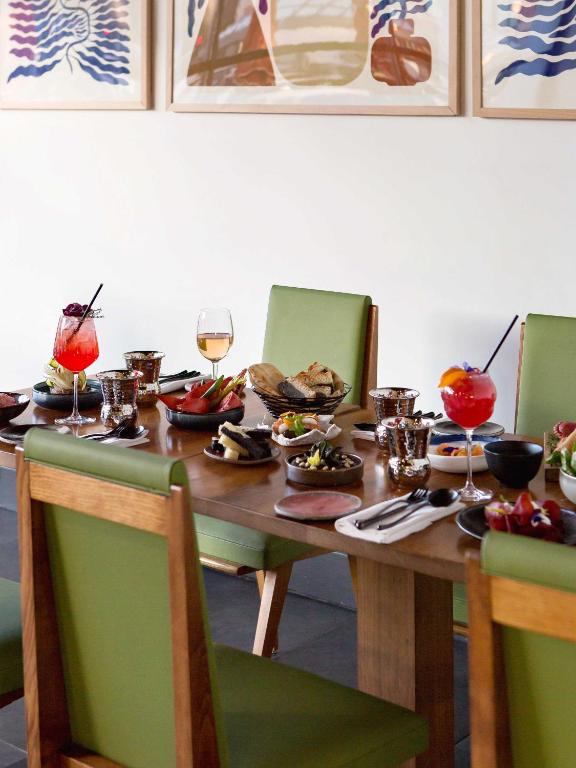 a wooden table with plates of food and glasses of wine at New Hotel of Marseille - Vieux Port in Marseille