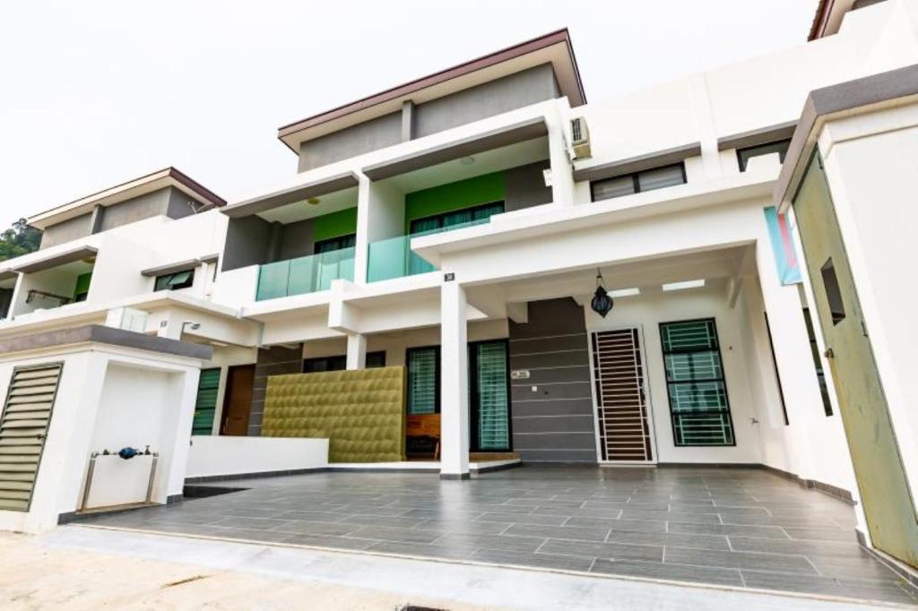 a house with a courtyard in front of it at HyperTribe -Pangkor Holiday Home in Kampong Sungai Udang