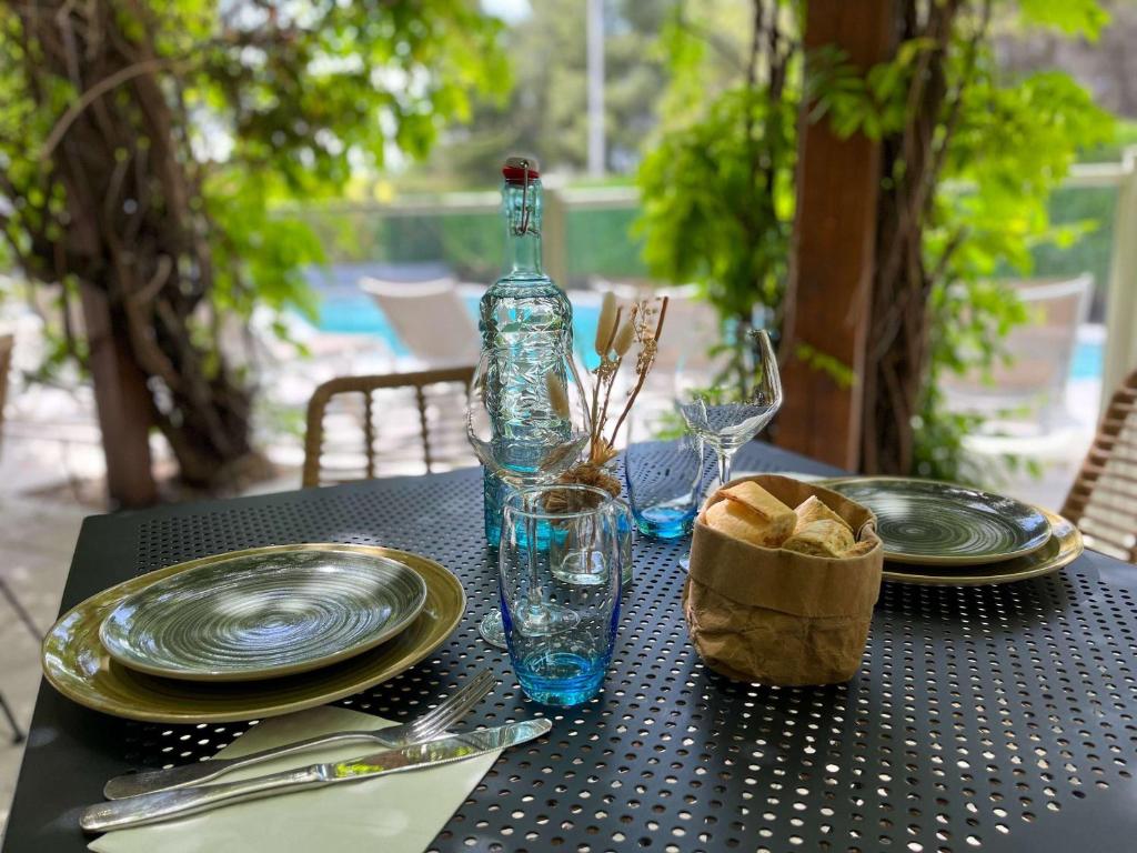 une table avec des assiettes et une bouteille au-dessus dans l'établissement ibis Nîmes Ouest - A9, à Nîmes