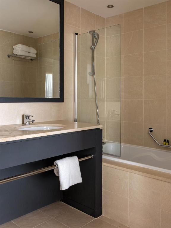 a bathroom with a sink and a tub and a shower at New Hotel of Marseille - Vieux Port in Marseille