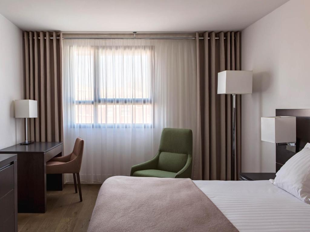 a hotel room with a bed and a chair and a window at New Hotel of Marseille - Vieux Port in Marseille
