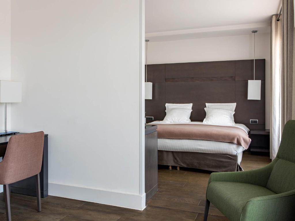 a bedroom with a bed and a desk and a chair at New Hotel of Marseille - Vieux Port in Marseille
