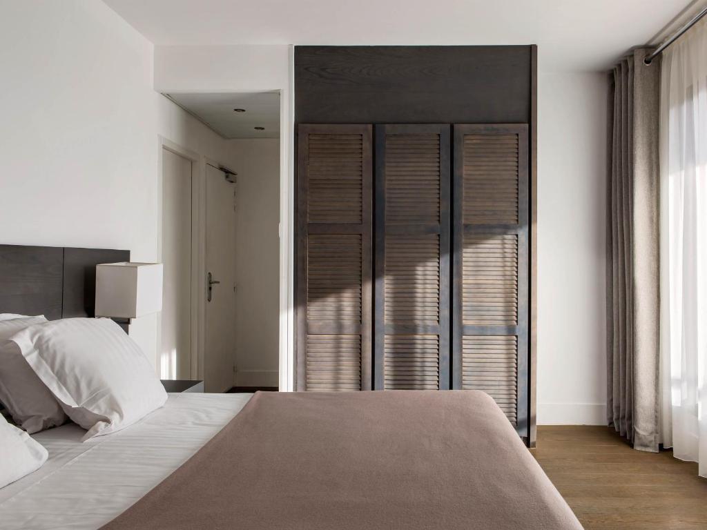 a bedroom with a large bed and a large window at New Hotel of Marseille - Vieux Port in Marseille